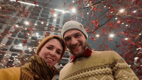 Winter holidays concept. Happy young couple taking selfie by smartphone at Christmas market in Belgrade, Serbia. Man and woman having fun together vlogging looking at camera - Powered by Shutterstock - Get 15% off with code: PIKWIZARD15