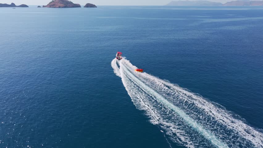 Aerial view of a speedboat creating waves in the clear blue waters of the mediterranean sea, Fethiye, Turkey.