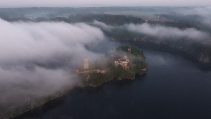 Aerial view of Zvikov Castle and the Moldau river at sunrise surrounded by fog, Zvikovske Podhradi, Czech Republic.