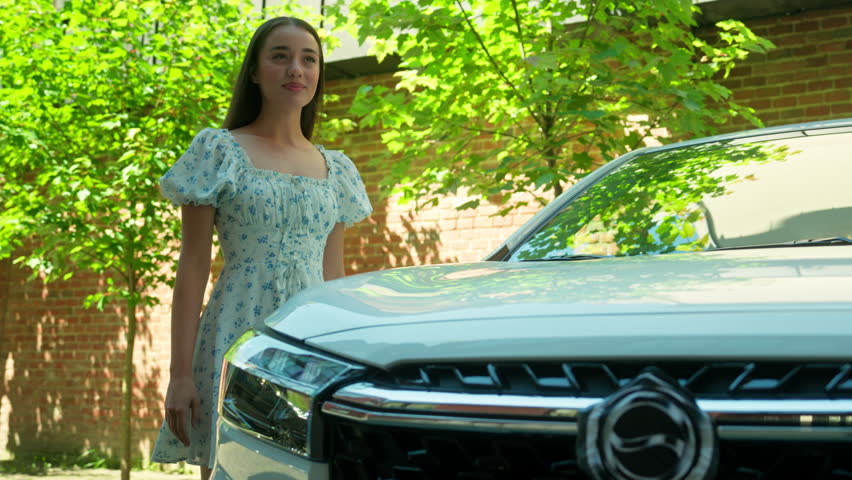 Joyful glad Caucasian woman female girl client customer happy car buyer automobile owner hugging embracing hood buy new auto transportation rental service dreaming buying vehicle outside town street