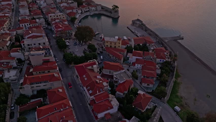 Aerial view of Naupactus Venetian Port at sunrise with beautiful coastline and historic buildings, Nafpaktos, Greece.
