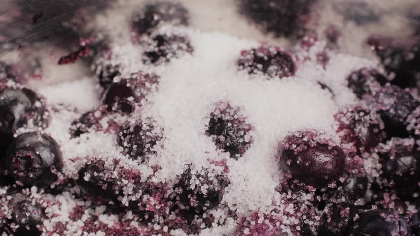 Cooking blueberry raspberry berrie jam with sugar, boiling marmalade, Jar of raspberry jam and fresh berries with leaves on a white wooden table.