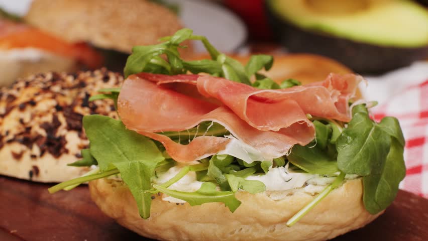Bagel sandwich brunch, lunch plate of a bagel with smoked salmon and cream cheese and ham, close up morning cafe menu.