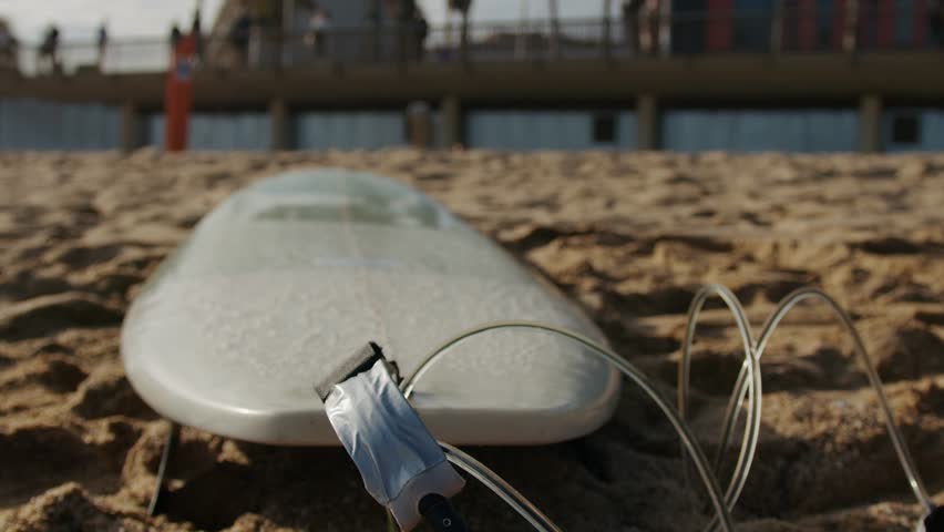 Surfer man walking to the beach at sunset wax preparing for surfing training and search for waves in Barcelona, spain, water, ocean exercise in sea with board, athletic male holiday or travel.