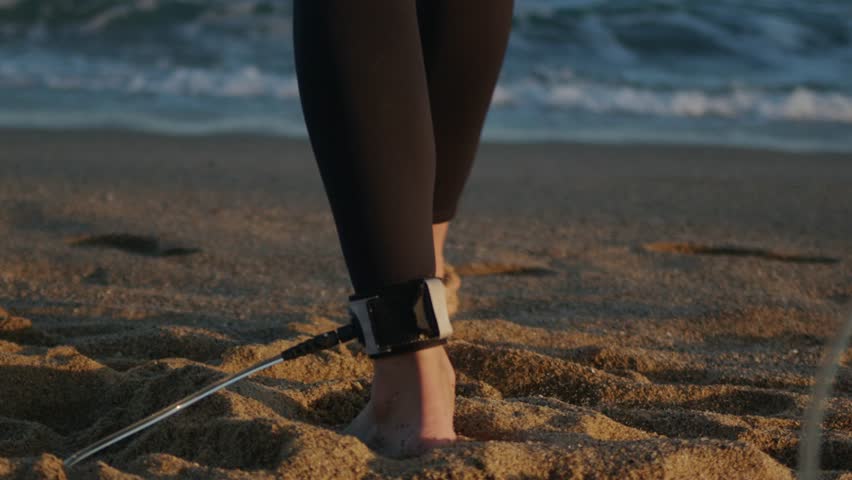 Surfer man walking to the beach at sunset preparing for surfing training and search for waves in Barcelona, spain, water, ocean exercise in sea with board, athletic male holiday or travel in vacation.