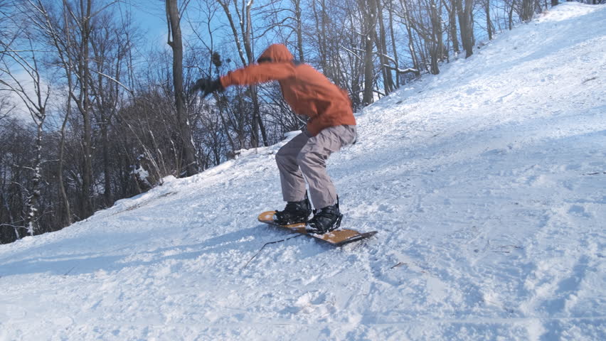 Beginner man snowboarder standing on snowboard, sliding down snowy mountain slope at winter resort. Active lifestyle in cold frost. Sport leisure in snow sunny ski resort. Newbie practice snowboarding