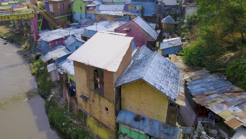 Descending Aerial shot of the rainbow village blue houses a famous destination in Malang (Jodipan), Java, Indonesia