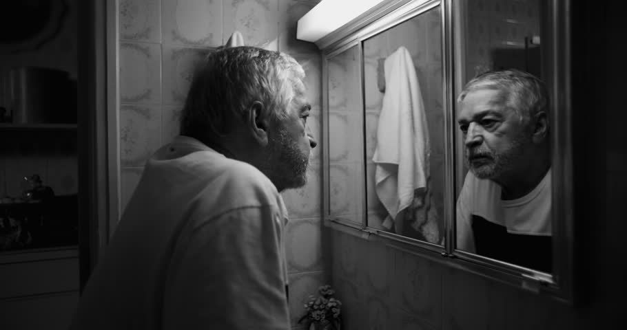 Elderly man gazing into his reflection in a bathroom mirror, confronting inner turmoil, despair, and the weight of aging in a deeply personal and haunting moment