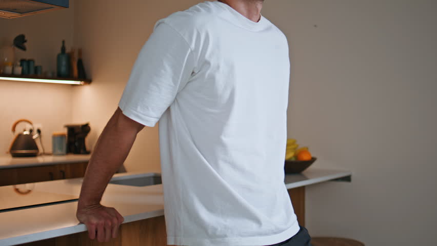 Sporty man practicing dips on kitchen counter at home fitness routine closeup. Strong athlete performing bodyweight exercise caring of healthy muscular body. Hispanic sportsman exercising in apartment