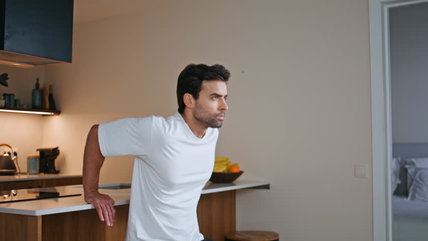 Motivated man performing dips on kitchen counter at strength training home closeup. Focused athlete practicing sport exercises enjoying physical activity. Determined workout showcasing body wellness.