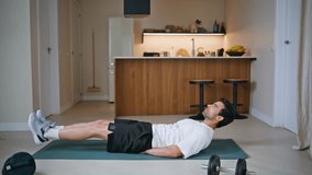 Fitness guy raising legs lying on sport mat at core training exercises. Determined sportsman pumping abdominal muscles on apartment floor. Active hispanic man training muscular healthy body indoors. - Powered by Shutterstock - Get 15% off with code: PIKWIZARD15