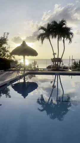 Early morning view at the tropical resort in Key Largo, Florida. Swimming pool, palm trees and view to Mexican Gulf.