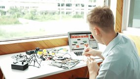 Caucasian student looking at laptop screen while coding engineering prompt or programming system. Back view of teenager working by using computer and electronic tool repair main board.. Edification - Powered by Shutterstock - Get 15% off with code: PIKWIZARD15