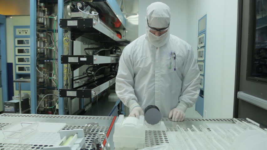 Scientist / technician preps silicon wafers and puts them on a tray to go into a