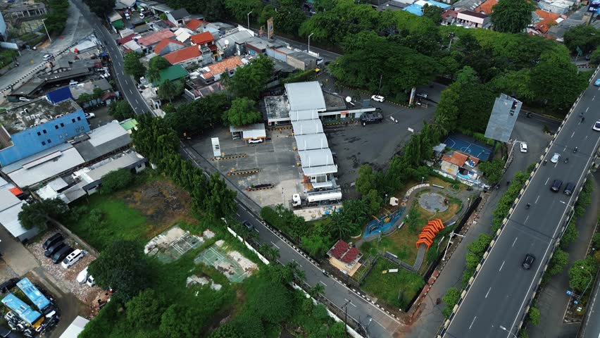 High-angle drone footage of a gas station in a city. Perfect for urban, transportation, or infrastructure projects. DKI Jakarta, Indonesia - Januari 07 2025