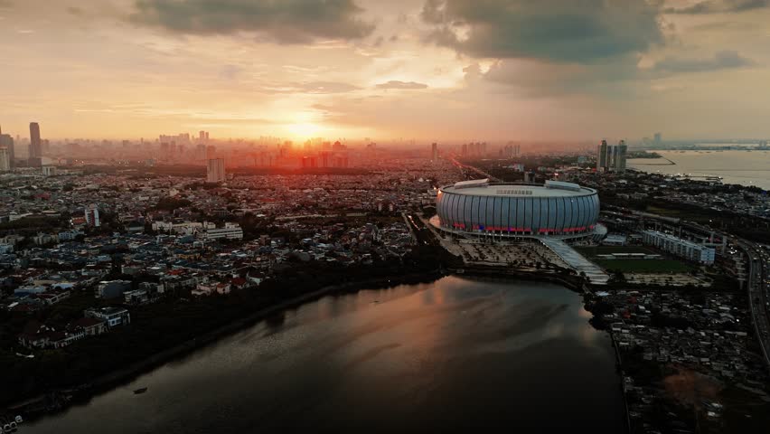 An aerial view of beautiful sunset from the sky, capturing the popular of Jakarta International Stadium (JIS) in the late afternoon. Drone view of International Stadium of Jakarta in the afternoon.