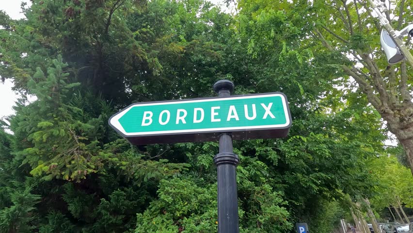 Sign pointing towards Bordeaux amidst lush greenery