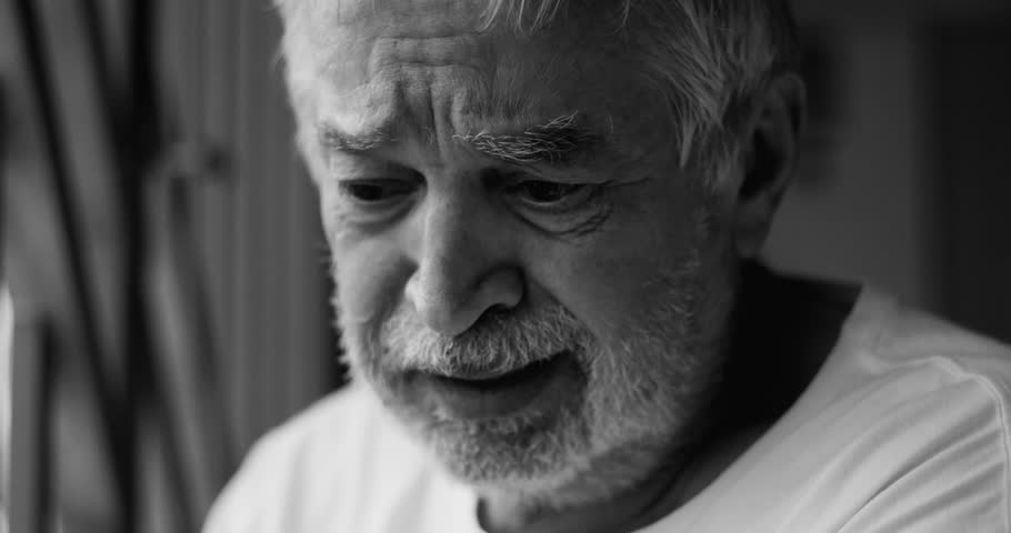 Elderly man close-up with tearful expression of deep sorrow, despair, and emotional pain, experiencing loneliness and hopelessness in solitude, black and white