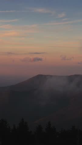 Vertical screen Misty Sunset Over the Smoky Mountains, USA breathtaking view of Smoky Mountains enveloped in mist during serene sunset with soft pastel hues painting sky sunset