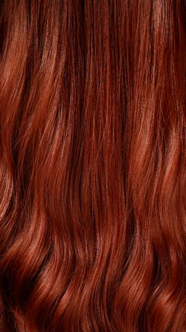 Vertical blond hair texture, slow motion of female hand combing long curly hair