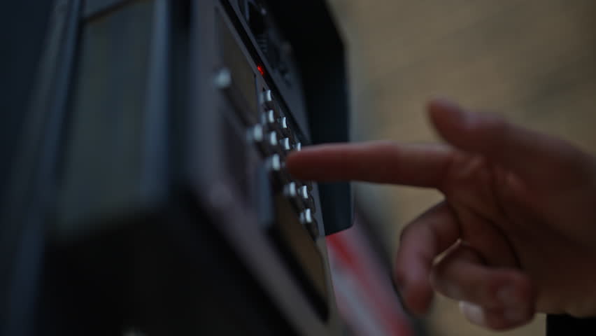 Low-angle view of finger pressing button on intercom keypad, located on building exterior, allowing access to resident or employee. Concept of modern technology connecting visitors to secure entrances