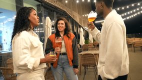 Multi-ethnic friends talking while drinking beer at night in an elegant roof terrace of a bar - Powered by Shutterstock - Get 15% off with code: PIKWIZARD15