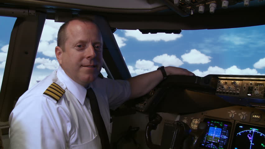 Commercial pilot sitting at the controls in the cockpit of a 747 Jumbo Jet.