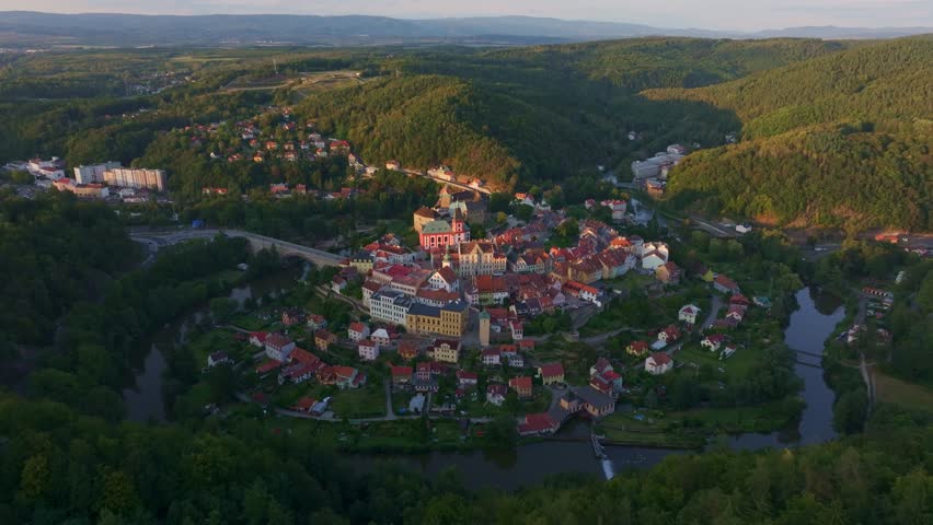 Aerial view of Loket village with the Ohre river at sunset surrounded by mountains and forest, Karlovy Vary, Czech Republic.