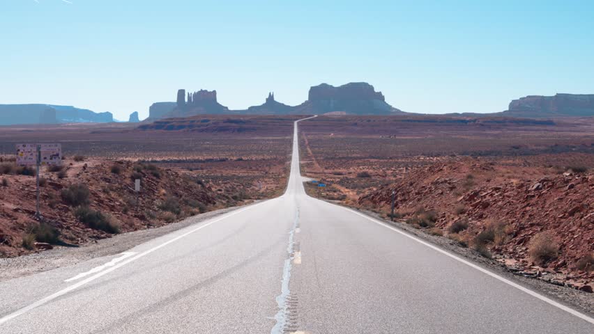 A pull back shot of the long lonely road leading to Monument Valley in Arizona, USA