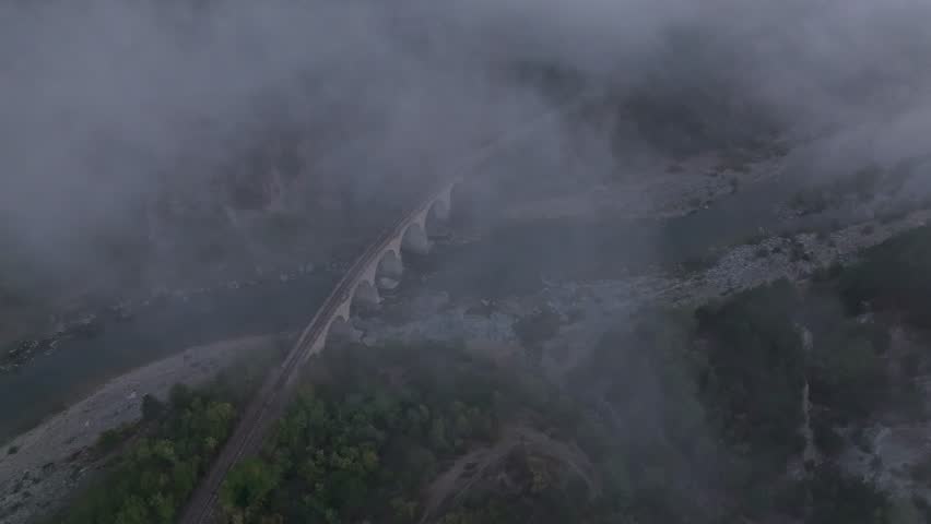 Aerial view of a railway bridge over the foggy Varbitsa River at sunrise, Balabanovo, Bulgaria.