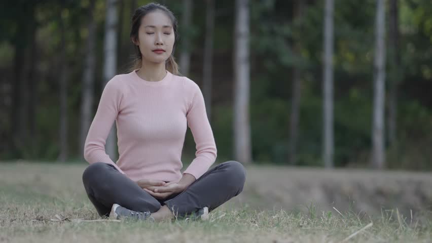 A woman is meditating and relaxing in the garden.