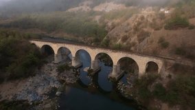Aerial view of railway bridge over varbitsa river at sunrise surrounded by misty forest and mountains, Balabanovo, Bulgaria. - Powered by Shutterstock - Get 15% off with code: PIKWIZARD15