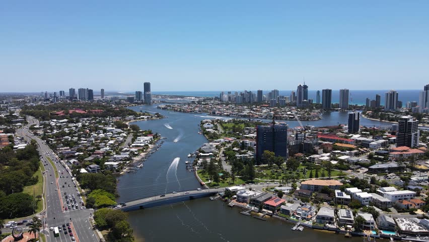 Towering urban city skyline of the iconic Gold Coast with intertwining network of residential canal waterways. Creative drone view