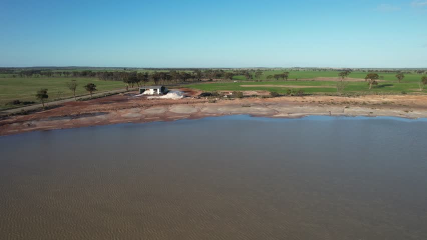 Aerial view of abstract patterns over Lake Kurrenkutten with serene shoreline and rural fields, Kurrenkutten, Australia.