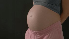 A close-up of a pregnant woman's belly as she proudly shows a 3D ultrasound image of her unborn child. This intimate moment captures the joy and anticipation of motherhood, emphasizing the bond - Powered by Shutterstock - Get 15% off with code: PIKWIZARD15