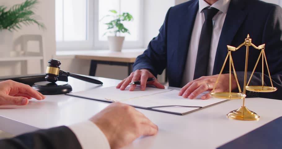 Close up shot of a lawyer or attorney working with a client during a meeting in an office, discussing legal documents, contract negotiations, and providing law services during conversation.