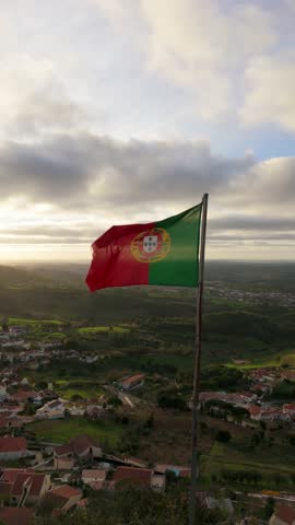 National Flag of Portugal, Village and Green Hilly Landscape at Sunset. Montejunto Mountains. Aerial View. Orbiting. Slow Motion. Vertical Video