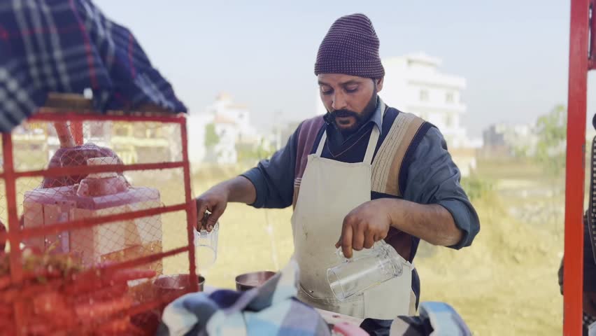 Man is pouring fresh carrot juice into glass. In winter fresh juice is liked by common people in Pakistan; fresh organic healthy juice