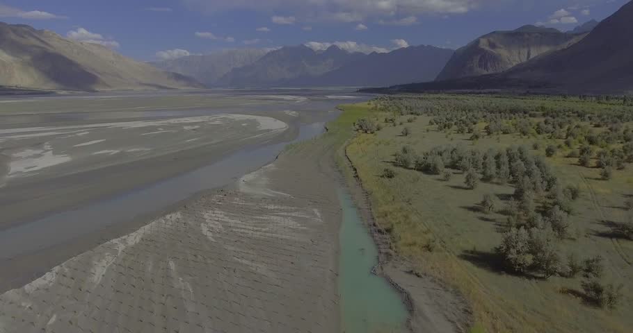 Aerial view of the majestic Indus River winding through rugged mountains and serene valleys, Gilgit Baltistan, Pakistan.
