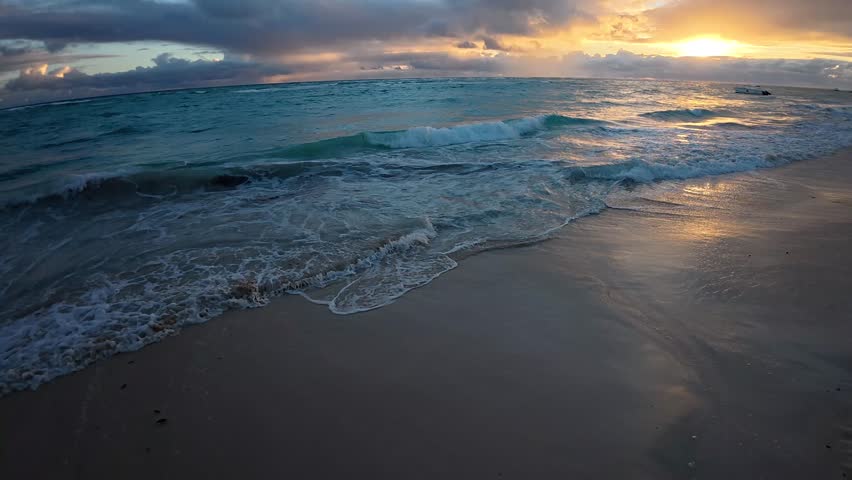 4k slow motion video of waves breaking on a beach at sunrise in Punta Cana, Dominican Republic
