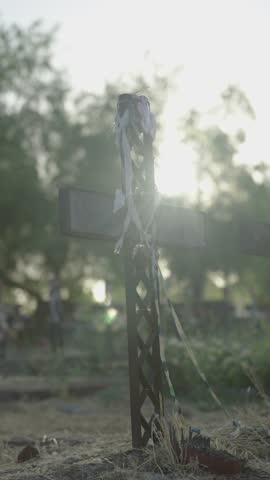 Rusted metal crosses in a rural cemetery with dried vegetation