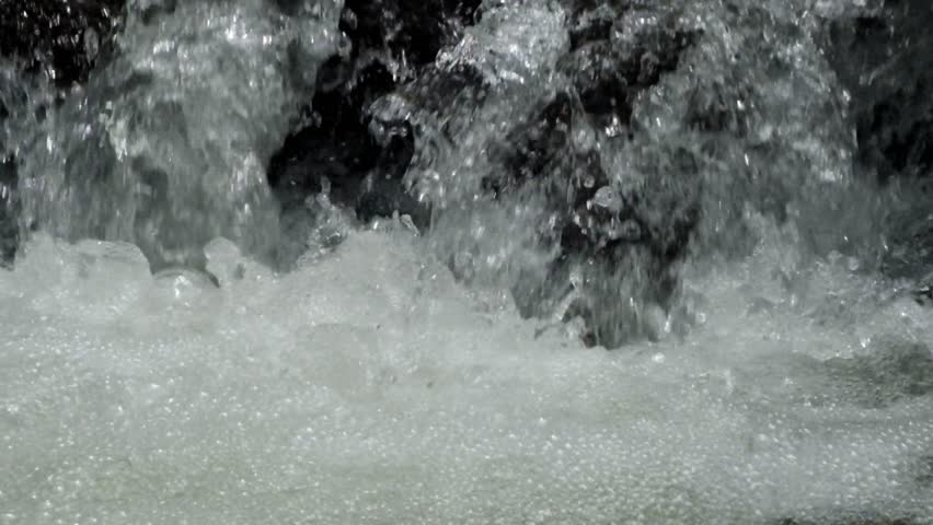 Close up of water falling through a rocky river cascade. A clear and natural river in the mountains. For relaxation and tranquility videos. Concept of ecology and a sustainable green environment