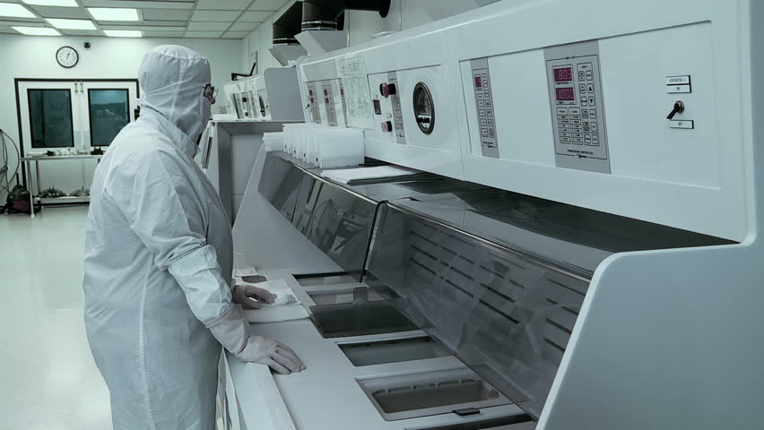 Scientist / technician processing silicon wafers through various chemical