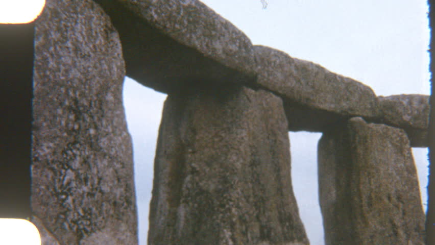Vintage shot of towering Stonehenge pillars standing tall against a clear blue sky, with timeless elegance and dramatic presence