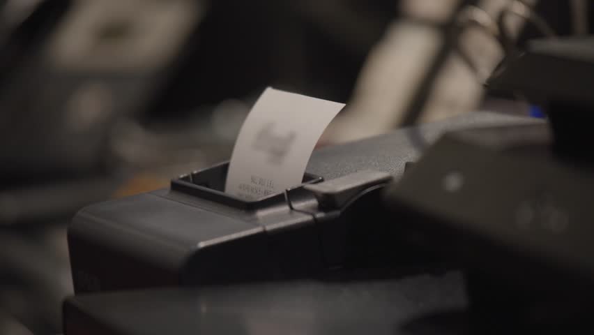 Restaurant receipt machine at the cashier. Payment terminal with thermal paper for receipt on a slightly dark background.