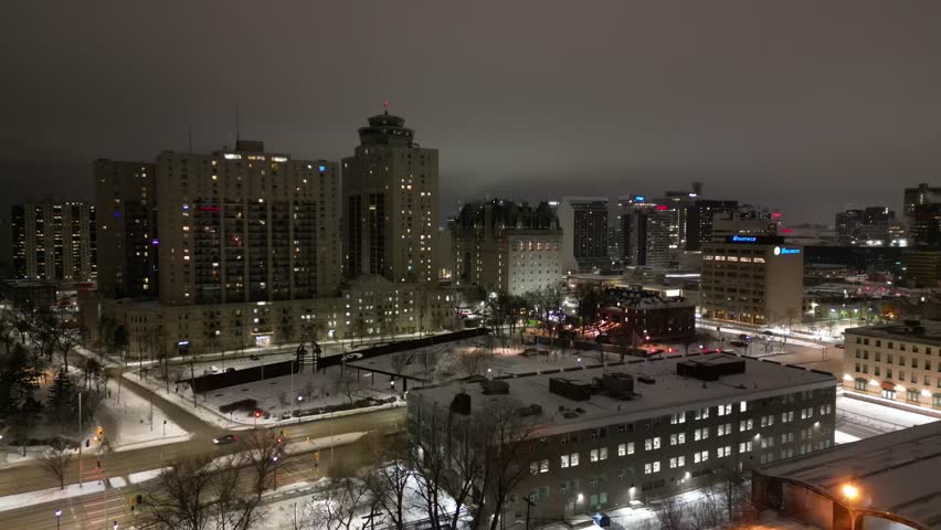 Downtown Winnipeg skyline on snowy winter night drone aerial