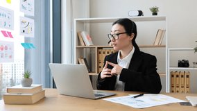 Asian businesswoman wearing headset participating in online meeting. Professional attire in modern office setting. Technology facilitating communication. - Powered by Shutterstock - Get 15% off with code: PIKWIZARD15