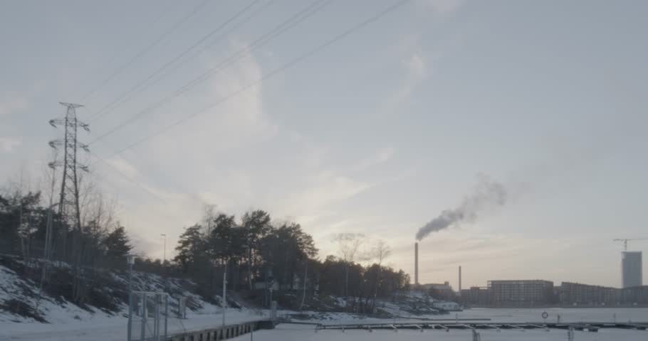 Evening view at Mustikkamaa marina with Kalasatama in the background in winter with sea frozen, Helsinki, Finland.