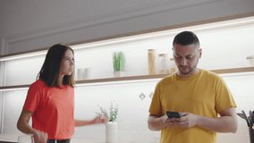 A couple argues in a modern kitchen, with the woman angrily shouting at the man who is distracted by his phone. The scene captures the intensity of their conflict and the emotional distance between - Powered by Shutterstock - Get 15% off with code: PIKWIZARD15