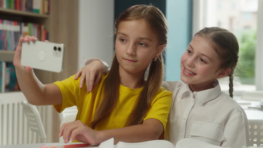 School education Caucasian little girls students pupils schoolgirls studying in classroom fun break posing selfie photo gadget addict female friends children teen bloggers kids mobile phone blog vlog